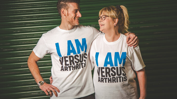 man with arm around  his mother in I am Versus t-shirts